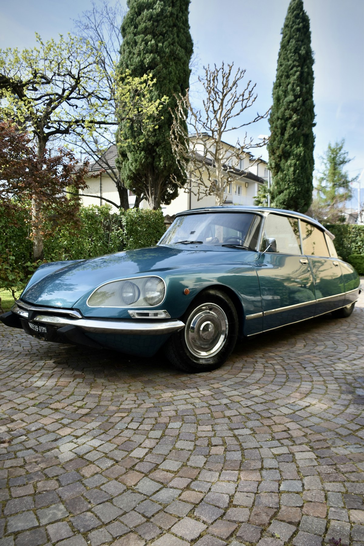 Citroën DS bleue de collection garée sur une allée pavée